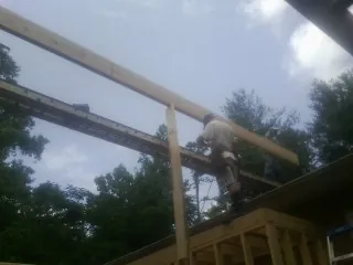 Carpenter setting a ridge beam over a new addition frame — Ice Dam Removal by Roofing Brothers in Grant Park