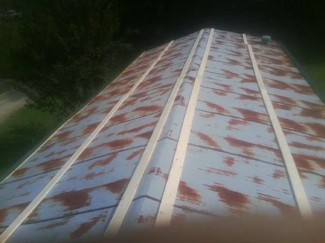 Rusted metal roof panels with new wood purlins before replacement — Storm Damage Roof Repair in Grant Park by Roofing Brothers