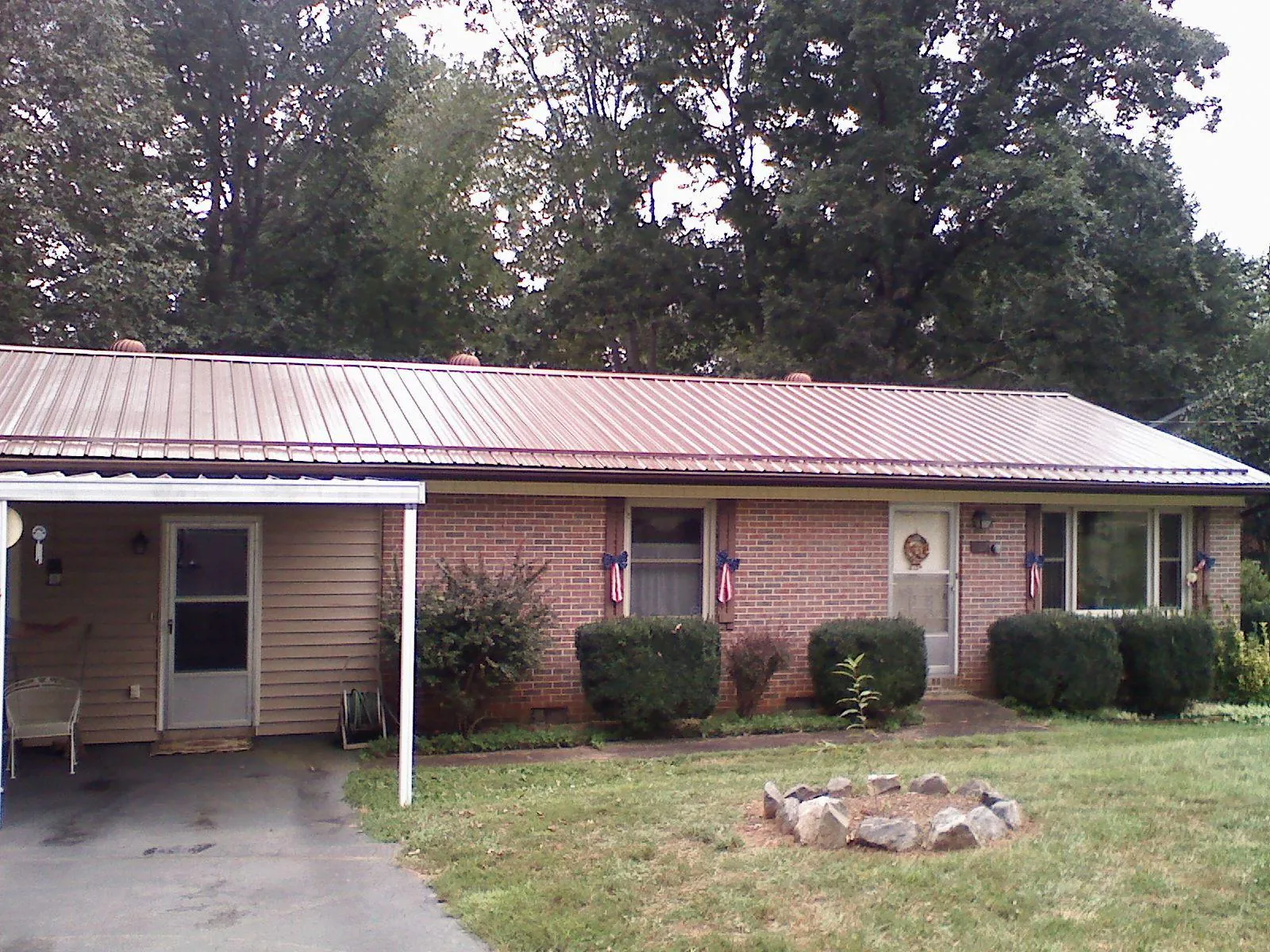 Bronze metal roof and carport on a brick ranch home — Roof Repair work by our crew in Grant Park