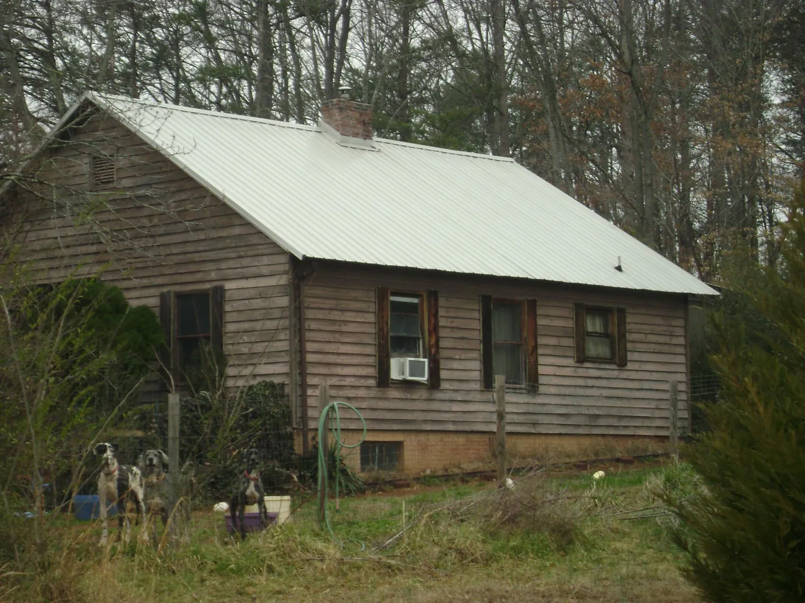 White metal roof on an old wood sided farmhouse, from a Metal Roof Installation job in Grant Park